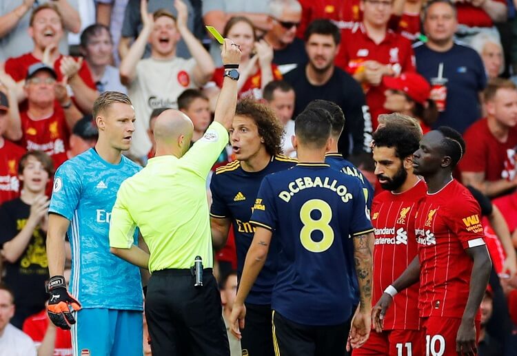 Arsenal's David Luiz talks to the referee after receiving a yellow card during a Premier League game against Liverpool